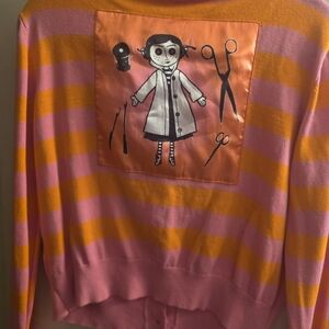 ⁶Pink and Orange Striped Sweater with Graphic Coraline Patch & Pictured Button